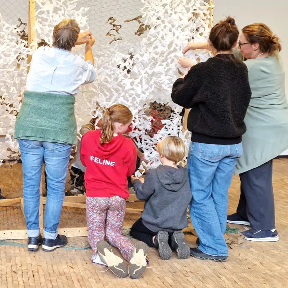 Adults and children weaving a net together; illustrative workshop photograph supplied by Expo Bart.